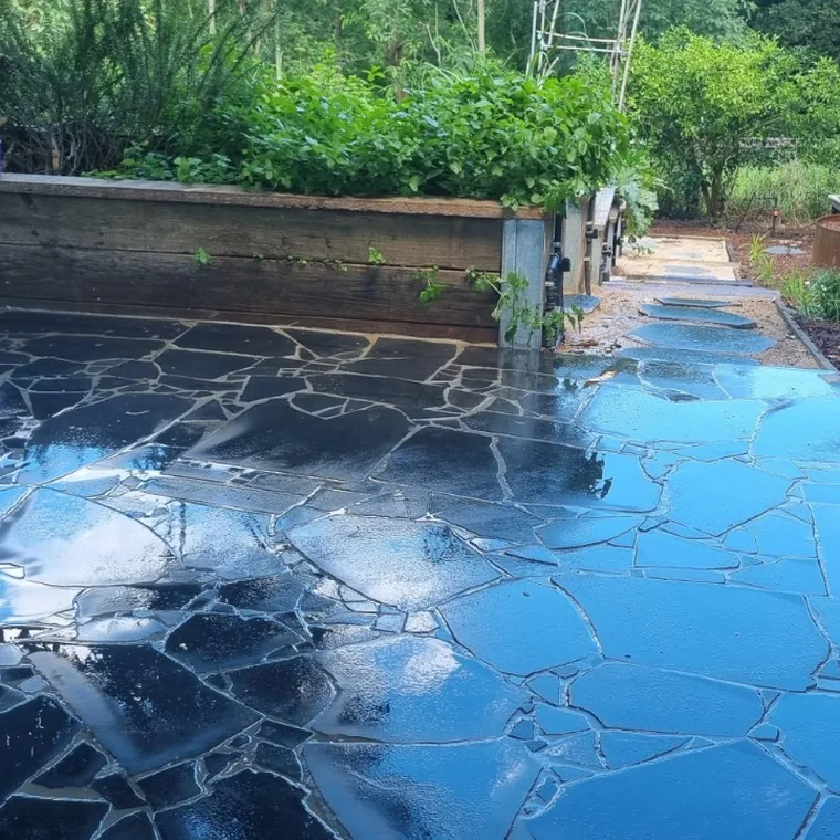Dark bluestone crazy paving laid around the edge of a swimming pool